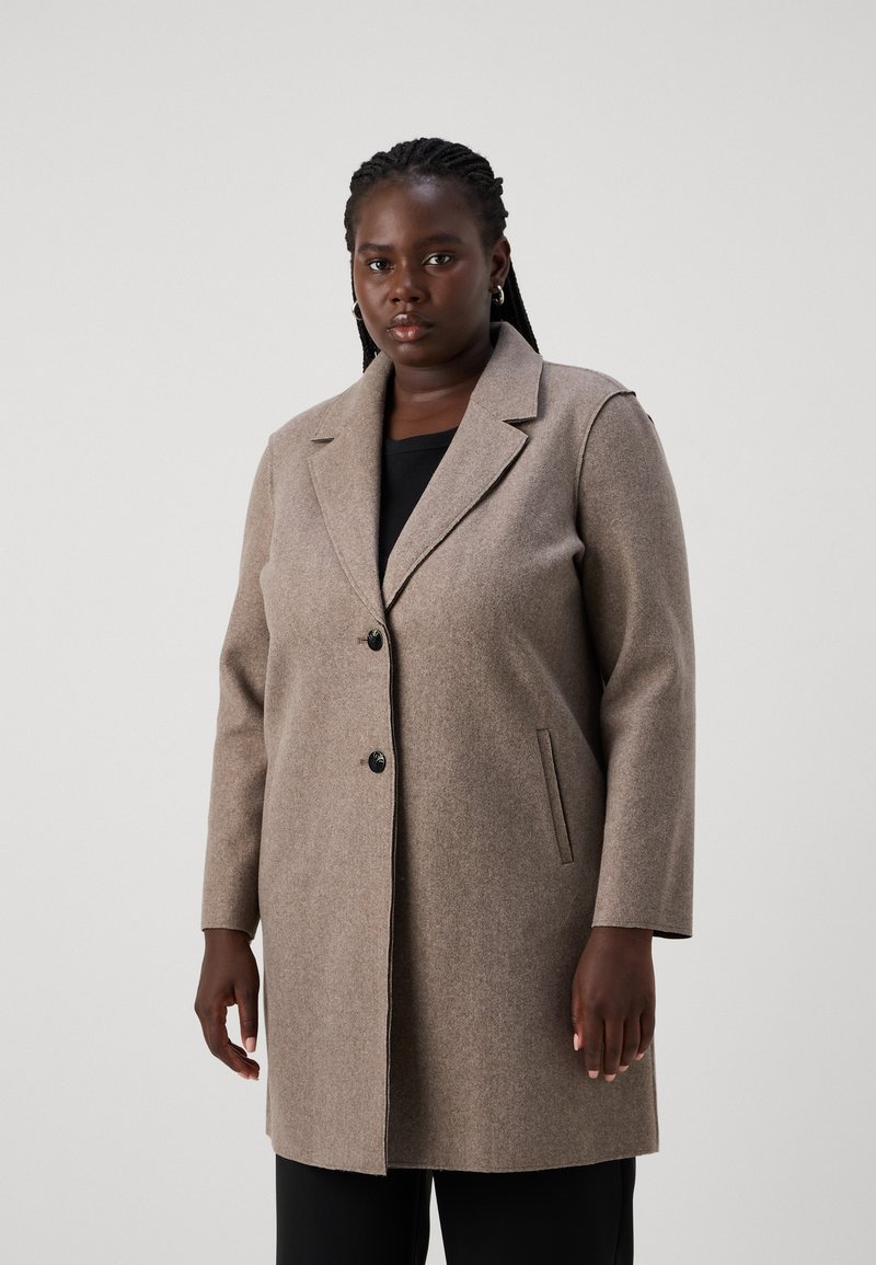 Manteau en mélange de laine brun clair avec un col en pointe, deux poches avant et une fermeture à un bouton. Manches longues, coupe ajustée.