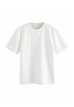 Tricou alb cu maneci scurte, având un model texturat în formă de vafe. Dispune de un guler rotund și bordură ribbată. Finisare a țesăturii netedă.