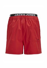 Červené plavecké šortky s elastickým pasem a černým logem JACK & JONES. Obsahují boční kapsu pro uložení. Hladká, lehká tkanina.
