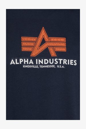 Marinblå T-shirt med en orange grafisk logotyp, med en stiliserad "A"-design och texten "Alpha Industries" nedanför i vitt.
