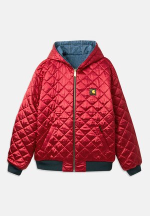 Sarkans quiltots mētelis ar kapuci, zelta rāvējslēdzis un priekšējām kabatām. Iekšpuse izgatavota no džinsa auduma, ar ribām uz piedurknēm un apakšmalu. Ietver logotipa uzšuvumu.