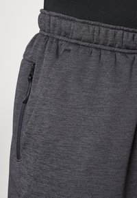 Gray jogger pants made of soft, textured fabric. Features an elastic waistband and a zippered pocket on the side.