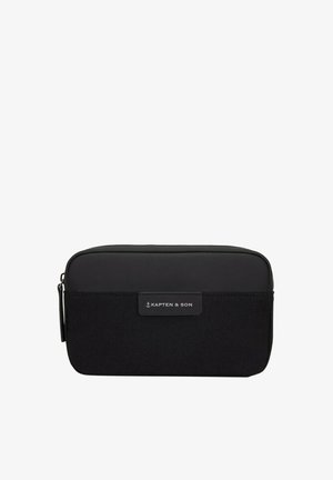 Černá obdélníková cestovní taška s hladkou horní částí a texturovaným spodkem; obsahuje značkovou nálepku a zipové uzávěr.