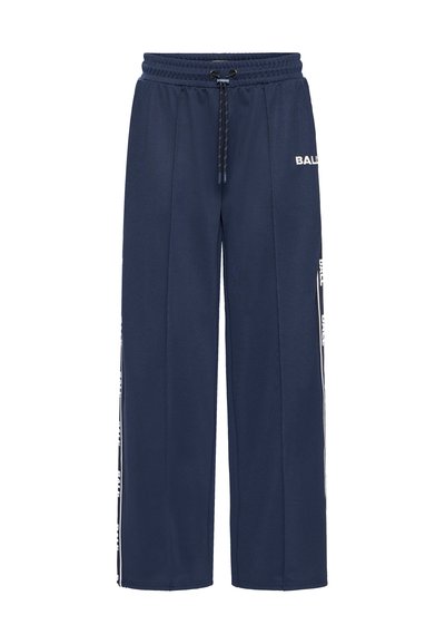 Pantalons de survêtement bleu marine en tissu texturé, dotés d'une taille élastique avec cordon de serrage et d'un logo blanc le long des coutures latérales. Design ample.