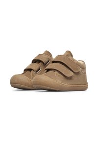 Scarpine per bambini in camoscio marrone, con due fasce in Velcro, punta arrotondata, suola in gomma testurizzata e fodera morbida. Design semplice e colore neutro.