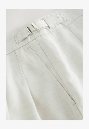 Tessuto color crema con una finitura testurizzata, caratterizzato da pieghe e una chiusura con fibbia argentata in vita.