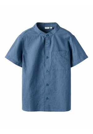 Lühikeste varrukatega nööbiga särk keskmiselt sinises kangas, millel on mandariinikaelus, üks rinna tasku ja tekstureeritud viimistlus.