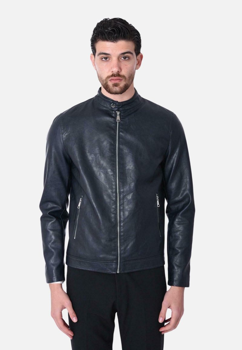 Giubbotto di pelle nera con colletto alto, chiusura frontale con zip e due tasche laterali con zip. Texture liscia, design aderente.