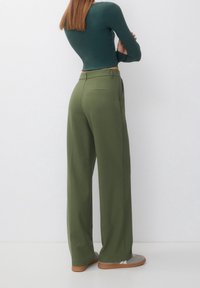 Wide-leg trousers in olive green fabric, featuring a smooth texture, two back pockets, and a high waist with belt loops.