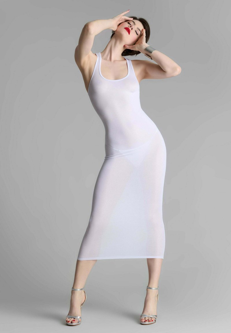 Weißes, tailliertes Tankkleid mit mittellanger Länge bis zur Wade, aus einem glatten, durchsichtigen Material gefertigt. Silberne Riemchen-Heels betonen den Look.