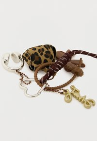 Conjunto de porta-chaves incluindo um suporte com padrão de leopardo, detalhes em metal prateado, argolas castanhas texturizadas e um pendente dourado com design "fun".