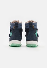 Mörkblå ankelboots med mjukt grått pälsfoder, en grön stjärndetalj och en vit och grön texturerad sula. Kardborreband.