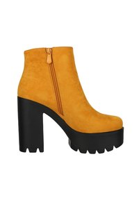 Botín amarillo de ante hasta el tobillo con cremallera lateral, plataforma y tacón grueso negro con textura estriada.