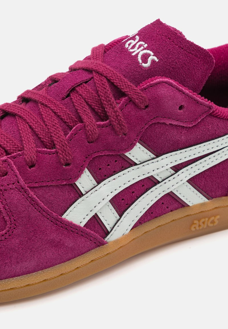 Baskets en suède fuchsia foncé avec des rayures en cuir blanc, un col rembourré, des lacets texturés et une semelle en gomme. Logo ASICS sur le côté.