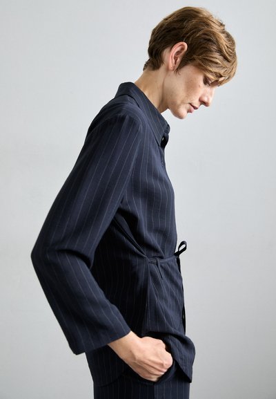 Marineblauwe blouse met streepjesmotief, met kraag, lange mouwen en een ceintuur in de taille. Glad stof met een getailleerde pasvorm en een zijzak.