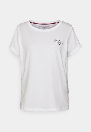 Vitt bomullströja med uppvikt ärm, försedt med en liten "Tommy Hilfiger"-logotyp på bröstet i svart och röd, rund halsringning.