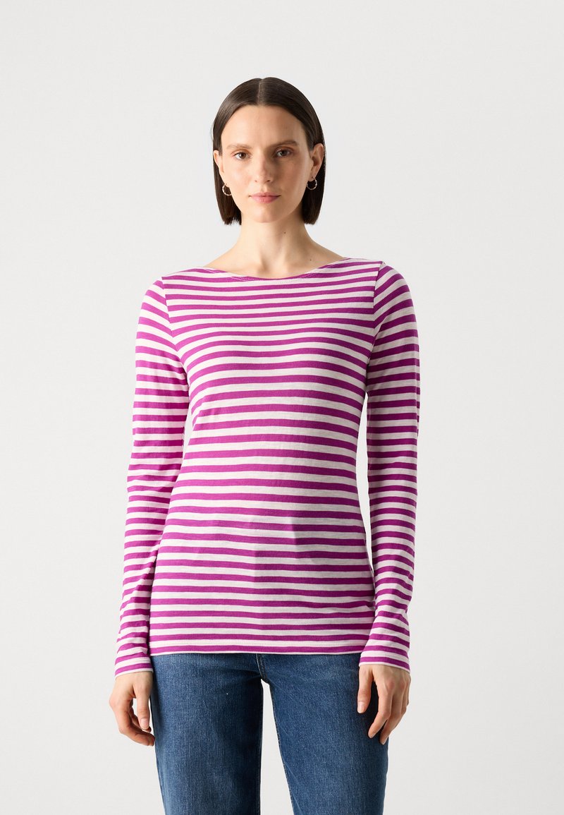 Langärmliges gestreiftes Oberteil in Pink und Weiß, aus weichem Stoff mit weitem Ausschnitt. Kombiniert mit blauen Jeans, die eine taillierte Passform zeigen.