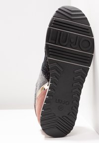 Sohle eines mehrfarbigen Sneakers mit strukturiertem schwarzem Gummi-Profil und eingeprägtem "LIU·JO"-Markenlogo, Größe 37 auf der Sohle markiert.