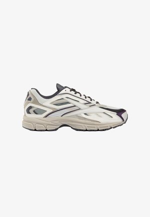 Scarpa da ginnastica bassa in bianco e beige con accenti neri e viola, pannelli in mesh e suola in gomma texturizzata.
