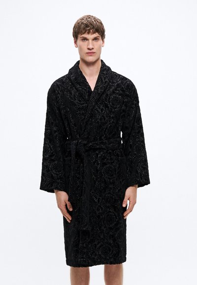Peignoir noir en tissu doux et texturé avec un motif floral. Il possède un col châle, des manches longues et une ceinture assortie.