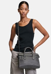 Graue Lederhandtasche mit einem strukturierten Design, stabilen Oberhandgriffen und einem abnehmbaren Schultergurt. Glatte Textur, detaillierte Nähte und sichtbares Markenlogo.