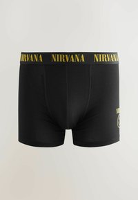 Boxers en coton noir avec le logo "NIRVANA" jaune sur la taille, offrant un ajustement serré et une texture lisse. Pas de motifs ou d'accents supplémentaires.