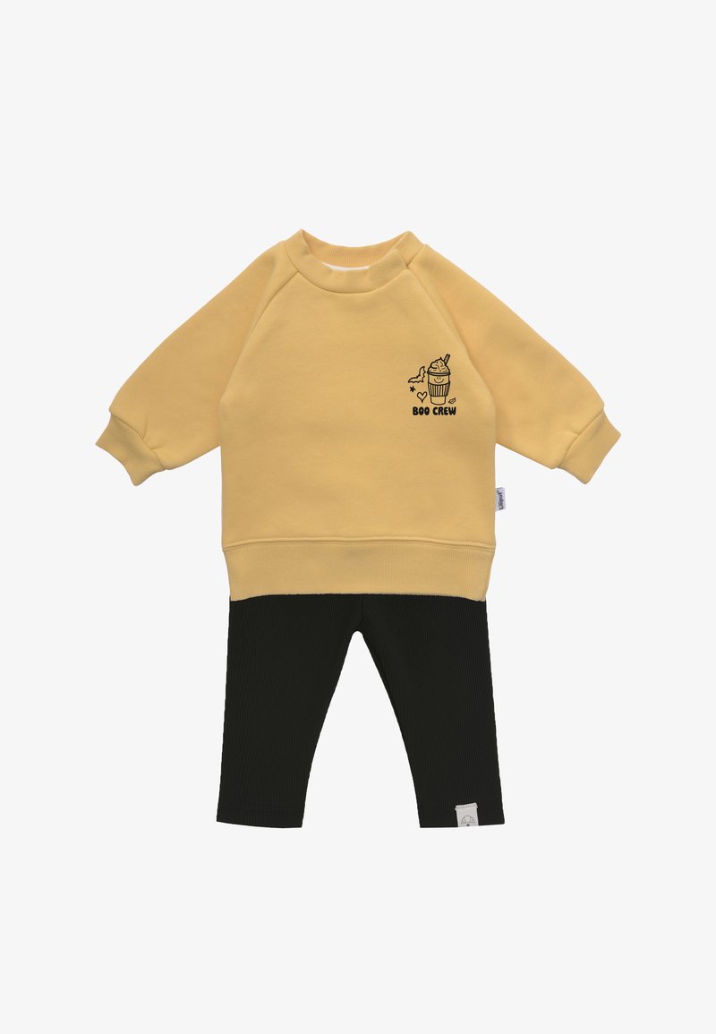 Gelbes Sweatshirt mit einem Cupcake-Grafik und dem Text "BOO CREW". Schwarze gerippte Leggings. Baumwollmaterial, lockerer Schnitt und Rundhalsausschnitt.