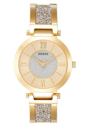 Montre-bracelet Guess ton or avec centre de cadran argenté scintillant, chiffres romains comme index horaires et accents en pierres scintillantes sur les maillons du bracelet.