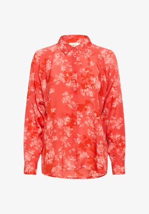 Piros, hosszú ujjú gombos ing világos rózsaszín virágmintával és hegyes gallérral, fehér háttér előtt.