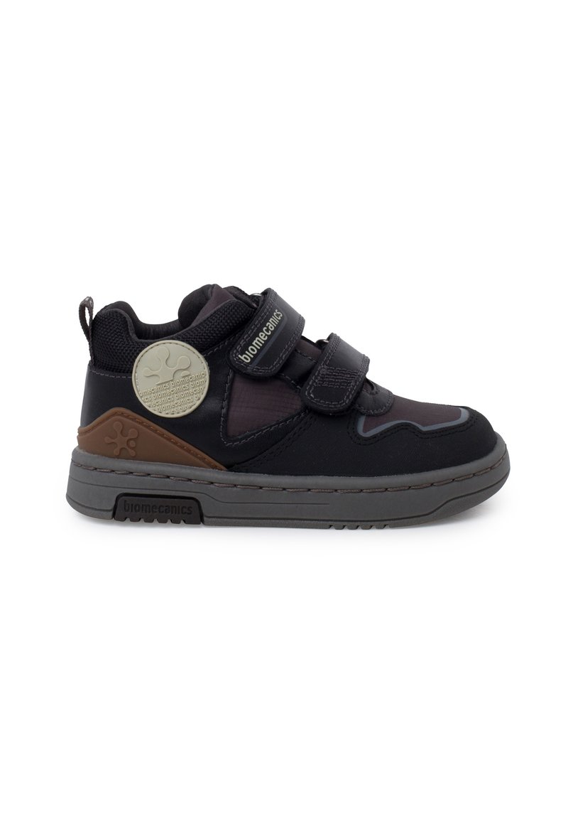 Sneaker neri per bambini con doppi cinturini in Velcro, tomaia in tessuto testurizzato, suola in gomma grigia e un accento marrone sul tallone.