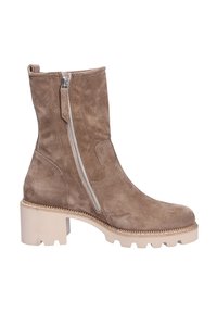 Bota de tobillo de ante beige con una suela gruesa de color claro y cremallera lateral. Cuenta con una punta redondeada y parte superior texturizada.