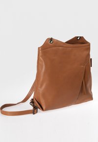 Braune Leder-Crossbody-Tasche mit strukturiertem Finish, asymmetrischem Oberteil, zwei Außentaschen und verstellbarem Tragegurt.