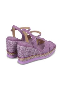 Sandales à plateforme en suède violet avec un design à lanière croisée et une plateforme en jute tressé. Elles présentent une fermeture à boucle et une semelle texturée.