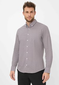 Camicia con bottoni a quadri rossi e blu navy, maniche lunghe e colletto con bottoni. Realizzata in tessuto leggero misto cotone.