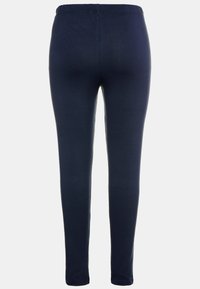 Námornícke modré legíny vyrobené z jemného a elastického materiálu, s vysokým elastickým pásom a priliehavým strihom.