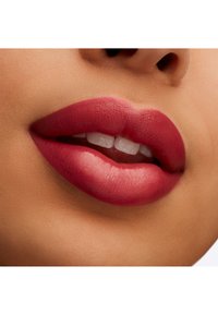 Rouge à lèvres rose profond mat appliqué sur des lèvres pulpeuses, mettant en valeur une texture lisse et un subtil éclat sur la lèvre inférieure, soulignant la forme naturelle.
