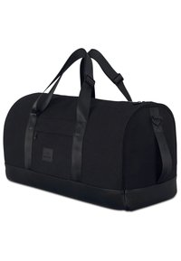 Černá taška přes rameno s kulatým tvarem, vyrobená z plátna s koženými akcenty, vybavená dvěma popruhy na nošení a zipovým uzávěrem.