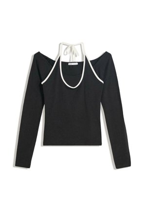 Zwarte cold-shoulder lange mouw top met een witte halternekband die achteraan geknoopt is, plat gelegd op een witte achtergrond.