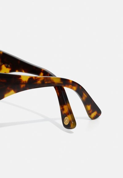 Tortoiseshell sunglasses with sleek, curved arms. Notable gold hardware accent on the temple. Smooth, shiny tortoiseshell pattern finish.