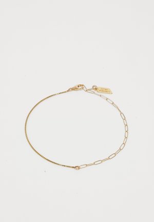 Pulsera de oro que presenta una combinación de una fina cadena de serpiente y eslabones ovalados, con un cierre de langosta y una pequeña etiqueta con un charm adjunto.