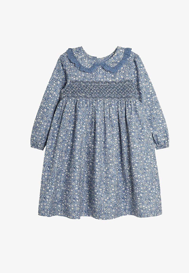 Mėlyna gėlių suknelė su ilgomis rankovėmis, sutrauktu bodu ir banguota apykakle. Pagaminta iš lengvos medžiagos, puošni baltų gėlių raštu.