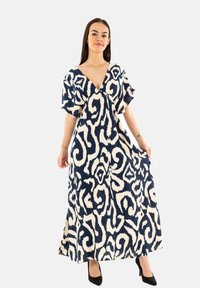 Abito lungo in blu navy e crema con motivo astratto, caratterizzato da una scollatura a V, maniche corte e un design fluente. Realizzato in tessuto leggero.