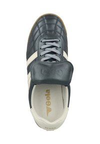 Sneaker Gola in bianco e nero con lacci grigio chiaro, design cucito e una fascia in Velcro sopra la linguetta, vista dall'alto.