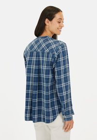 Blau-weiße Karos-Langarmhemd mit abgerundetem Saum und Knopfdetails an den Ärmelbündchen, aus leichtem Stoff mit strukturiertem Finish.