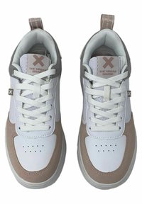 Zapatillas blancas y beige hechas de cuero y ante. Las características incluyen punta redonda, cuello acolchado, acentos texturizados y cordones planos.