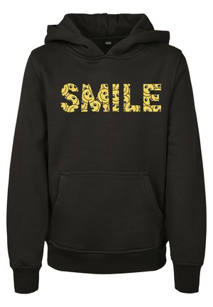 Čierna mikina s kapucňou, ktorá má veľkú grafiku "SMILE" vyplnenú žltými vzormi usmievajúcich sa tvárí. Obsahuje predné vrecko a rebrované manžety.