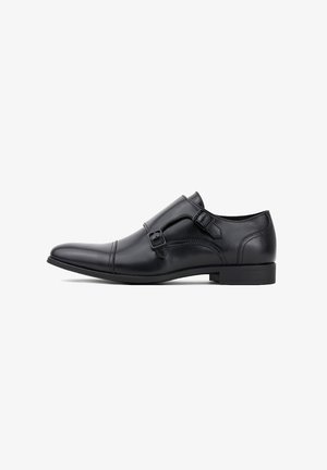 Czarne skórzane buty męskie eleganckie z podwójnym zapięciem na klamry, spiczastym noskiem i gładką fakturą. Posiadają niski obcas w kształcie bloku i minimalne przeszycia.