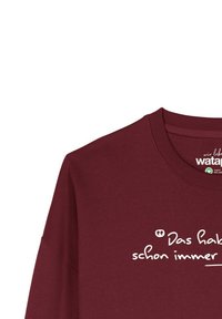 Bordeaux crewneck sweatshirt met witte Duitse tekst "Das habe ich schon immer..." aan de voorkant, gemaakt van biologisch katoen.