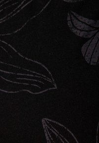 Černá látka s jemným květinovým vzorem v tmavě šedé barvě, s měkkou texturou a hladkým povrchem. Vzory zahrnují zakřivené linie a tvary listů.