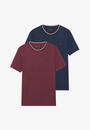 Two crew neck T-shirts, one burgundy and one navy, with contrasting striped collars and small embroidered logo on the chest.